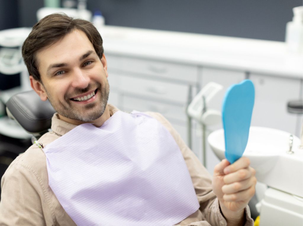 hombre en sillón feliz con sus implantes cigomáticos en gandia