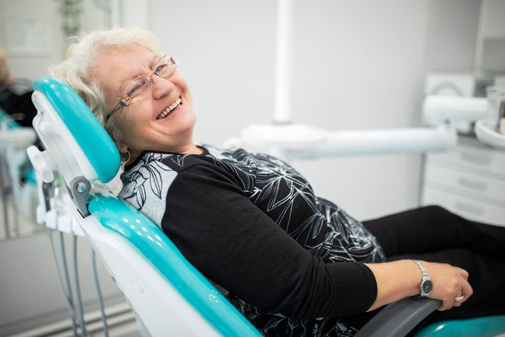 mujer en sillón de clínica dental sonriendo con implantes de carga inmediata en gandia